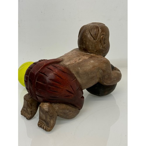 164 - Carved figure holding a ball. 26 cm long.

This lot is available for in-house shipping