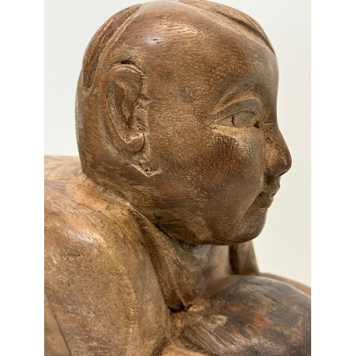 164 - Carved figure holding a ball. 26 cm long.

This lot is available for in-house shipping