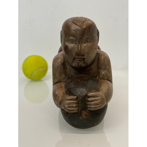 164 - Carved figure holding a ball. 26 cm long.

This lot is available for in-house shipping