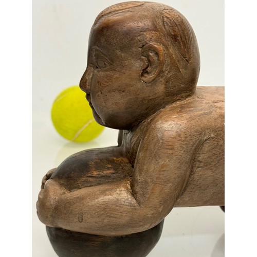 164 - Carved figure holding a ball. 26 cm long.

This lot is available for in-house shipping