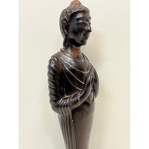 231 - A hand carved hardwood Buddist figure. 31 cm tall.

This lot is available for in-house shipping