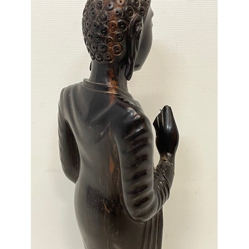 231 - A hand carved hardwood Buddist figure. 31 cm tall.

This lot is available for in-house shipping