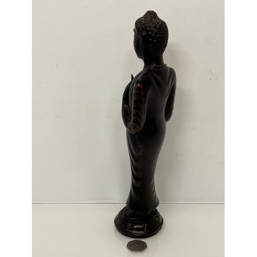 231 - A hand carved hardwood Buddist figure. 31 cm tall.

This lot is available for in-house shipping