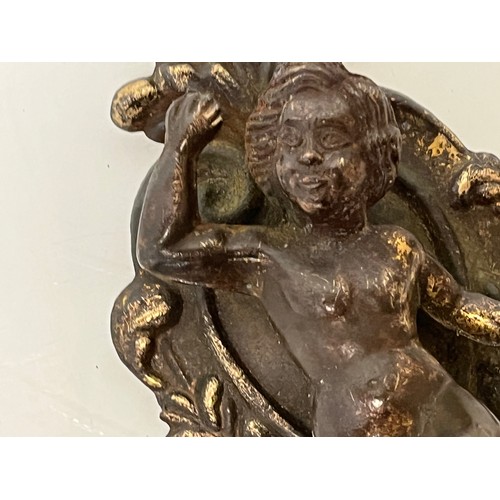 233 - A pair of cast furniture embellishments with cast in Cherub figures, each is 18 cm long.

This lot i... 