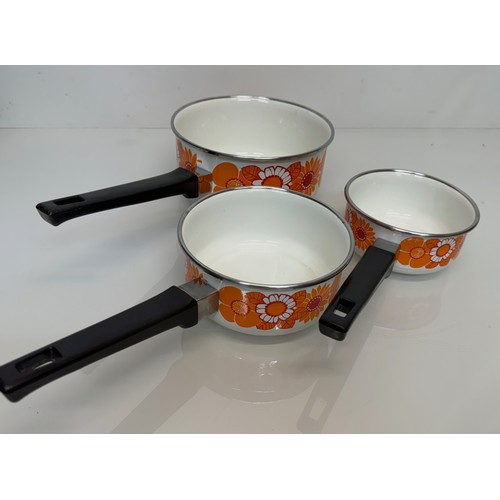 262 - Kitchenalia, three vintage enamelled 1970’s decorated saucepans, 13 cm 15 cm 19 cm in diameter.

Thi... 