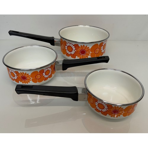 262 - Kitchenalia, three vintage enamelled 1970’s decorated saucepans, 13 cm 15 cm 19 cm in diameter.

Thi... 