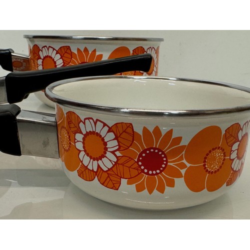 262 - Kitchenalia, three vintage enamelled 1970’s decorated saucepans, 13 cm 15 cm 19 cm in diameter.

Thi... 