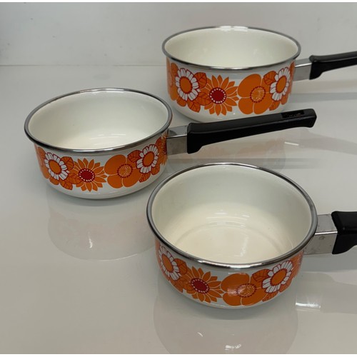 262 - Kitchenalia, three vintage enamelled 1970’s decorated saucepans, 13 cm 15 cm 19 cm in diameter.

Thi... 