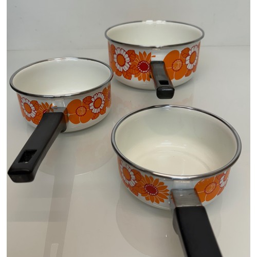 262 - Kitchenalia, three vintage enamelled 1970’s decorated saucepans, 13 cm 15 cm 19 cm in diameter.

Thi... 