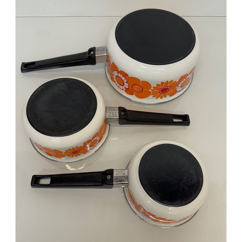 262 - Kitchenalia, three vintage enamelled 1970’s decorated saucepans, 13 cm 15 cm 19 cm in diameter.

Thi... 