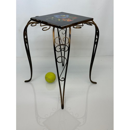 67 - Furniture, a kitsch tiled top wrought iron side table.

This lot is available for in-house shipping