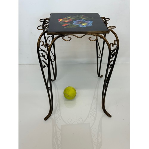 67 - Furniture, a kitsch tiled top wrought iron side table.

This lot is available for in-house shipping