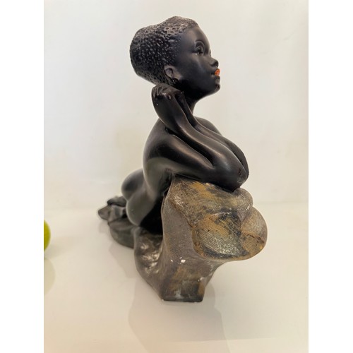 76 - Decorative figurine of a naked black female stretched out on a rock, 43 cm long.

This lot is availa... 