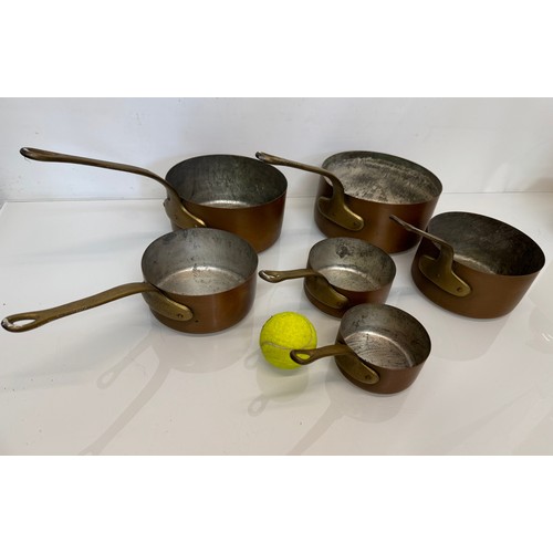 243 - Copper saucepans, a graduated set of six copper saucepans with cast brass handles, 10cm, 12cm, 14 cm... 