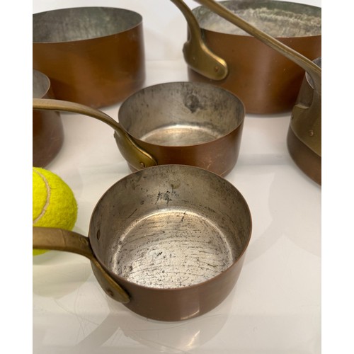 243 - Copper saucepans, a graduated set of six copper saucepans with cast brass handles, 10cm, 12cm, 14 cm... 