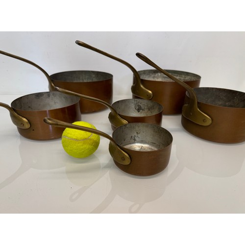 243 - Copper saucepans, a graduated set of six copper saucepans with cast brass handles, 10cm, 12cm, 14 cm... 