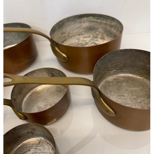 243 - Copper saucepans, a graduated set of six copper saucepans with cast brass handles, 10cm, 12cm, 14 cm... 