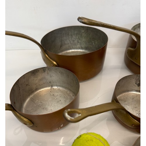 243 - Copper saucepans, a graduated set of six copper saucepans with cast brass handles, 10cm, 12cm, 14 cm... 