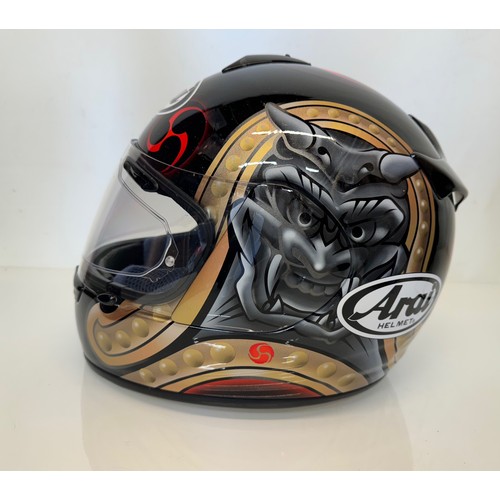 391 - Automobilia, an Arai Chaser motorcycle helmet decorated with devil graphics on a metal flack base co... 