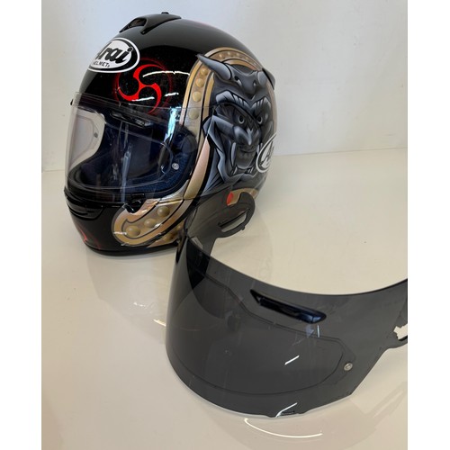 391 - Automobilia, an Arai Chaser motorcycle helmet decorated with devil graphics on a metal flack base co... 