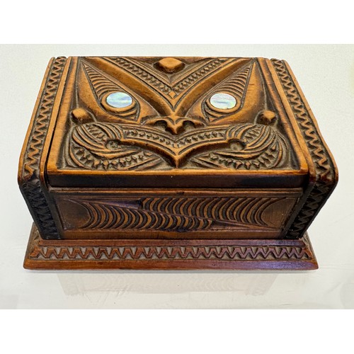 405 - Hand carved lidded box with a mask decoration to the lid with mother of pearl inserts, 12 cm x 9 cm ... 