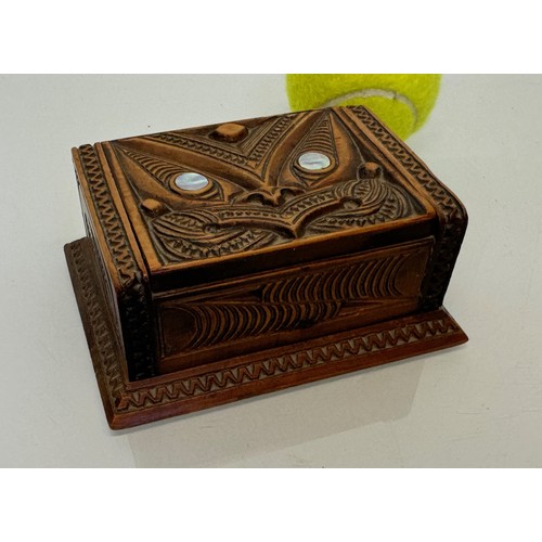 405 - Hand carved lidded box with a mask decoration to the lid with mother of pearl inserts, 12 cm x 9 cm ... 