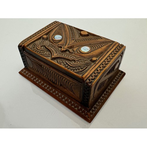 405 - Hand carved lidded box with a mask decoration to the lid with mother of pearl inserts, 12 cm x 9 cm ... 