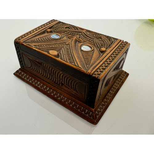 405 - Hand carved lidded box with a mask decoration to the lid with mother of pearl inserts, 12 cm x 9 cm ... 