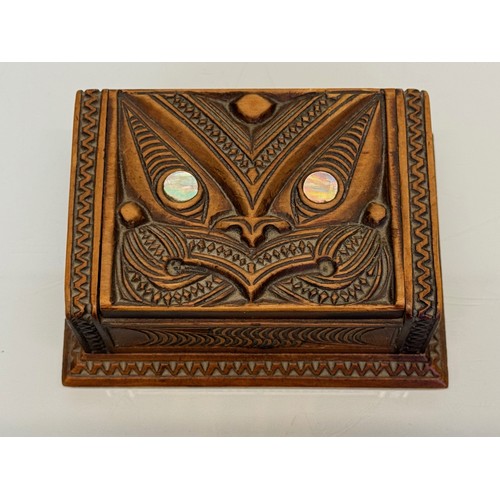 405 - Hand carved lidded box with a mask decoration to the lid with mother of pearl inserts, 12 cm x 9 cm ... 