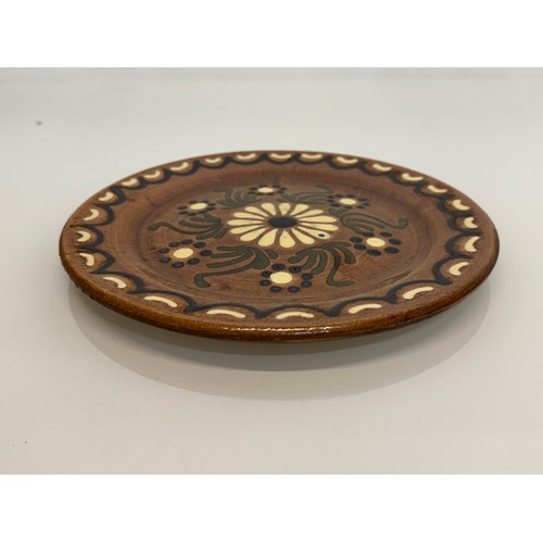 24 - A studio unmarked pottery plate with floral decoration, 23 cm diameter.

This lot is available for i... 