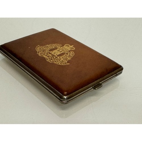 32 - Militaria, a vintage leather bound cigarette case marked for the Suffolk Regiment. 11.5 cm x 8 cm.

... 