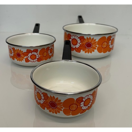 423 - Kitchenalia, three vintage enamelled 1970’s decorated saucepans, 13 cm 15 cm 19 cm in diameter.

Thi... 