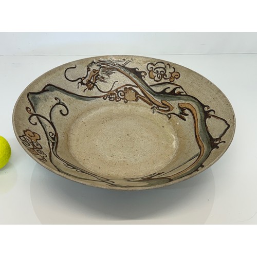 438 - Art pottery, a large stone ware bowl decorated with a dragon. 40 cm diameter x 10 cm high.

This lot... 