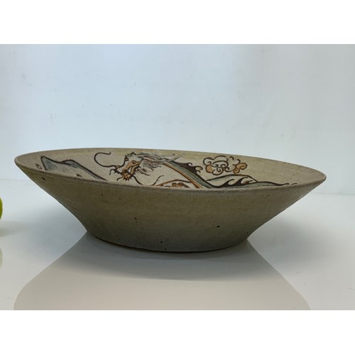 438 - Art pottery, a large stone ware bowl decorated with a dragon. 40 cm diameter x 10 cm high.

This lot... 