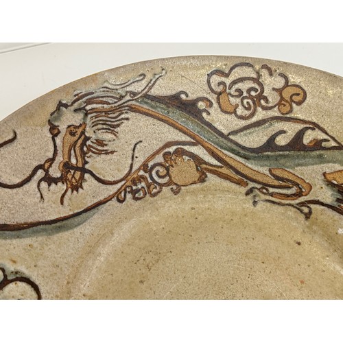 438 - Art pottery, a large stone ware bowl decorated with a dragon. 40 cm diameter x 10 cm high.

This lot... 