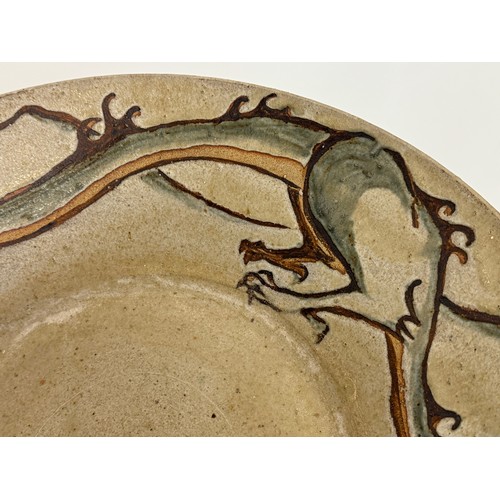 438 - Art pottery, a large stone ware bowl decorated with a dragon. 40 cm diameter x 10 cm high.

This lot... 