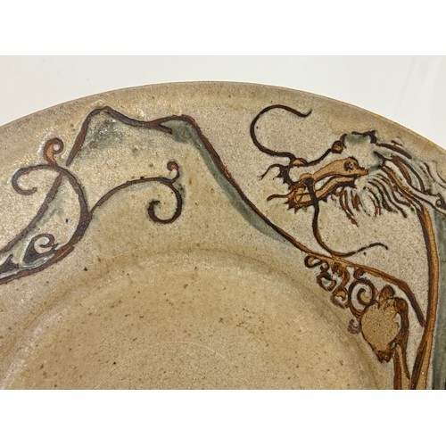 438 - Art pottery, a large stone ware bowl decorated with a dragon. 40 cm diameter x 10 cm high.

This lot... 