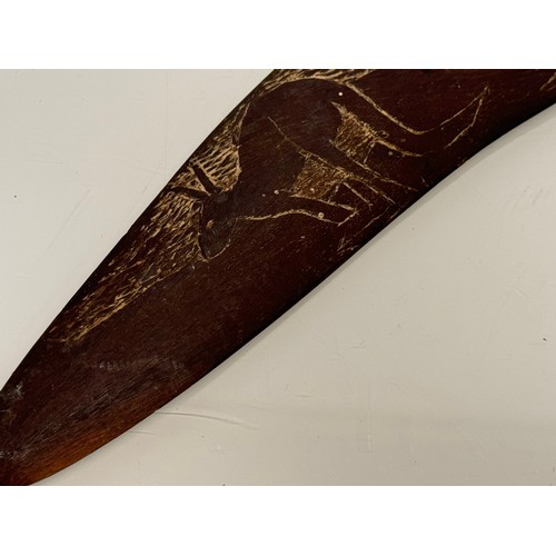 62 - Australian, Aboriginal, tribal art, a boomerang decorated with carvings of kangaroo’s, 45 cm wide.

... 