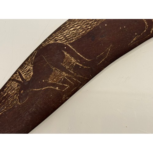 62 - Australian, Aboriginal, tribal art, a boomerang decorated with carvings of kangaroo’s, 45 cm wide.

... 