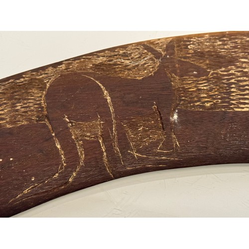 62 - Australian, Aboriginal, tribal art, a boomerang decorated with carvings of kangaroo’s, 45 cm wide.

... 