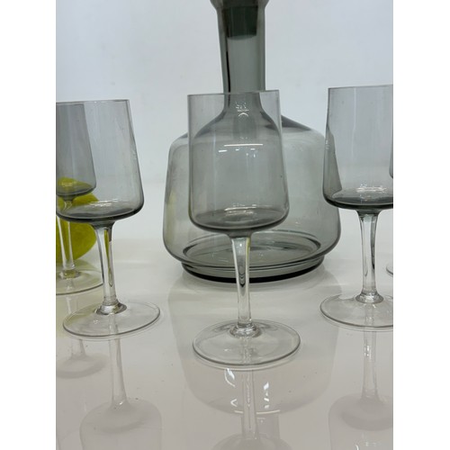 85 - Mid Century smoked glass decanter and glasses.

This lot is available for in-house shipping