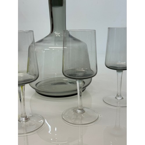 85 - Mid Century smoked glass decanter and glasses.

This lot is available for in-house shipping