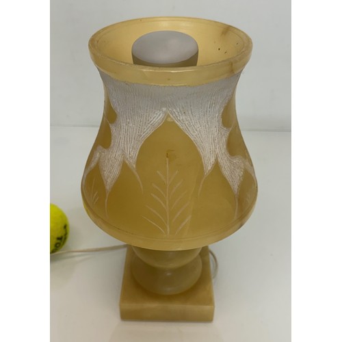 110 - A Carved stone table lamp, with hand carved floral and leaf designs to the shade section. 29 cm tall... 