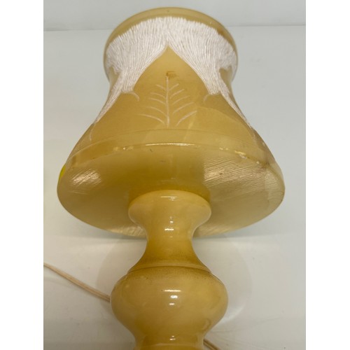 110 - A Carved stone table lamp, with hand carved floral and leaf designs to the shade section. 29 cm tall... 