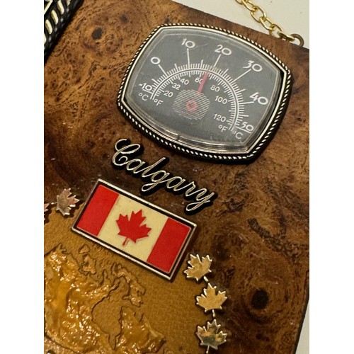 111 - A Calgary themed mid -century wall hanging thermometer 33 cm wide and a ceramic maple leaf wall pock... 