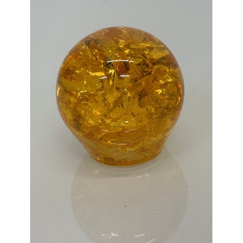 133 - An amber coloured resin paperweight, 6 cm high.

This lot is available for in-house shipping