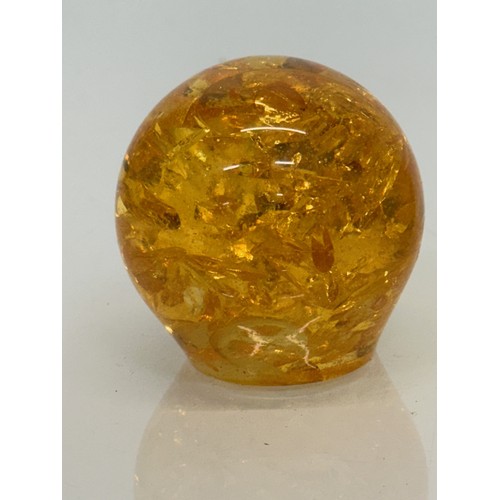 133 - An amber coloured resin paperweight, 6 cm high.

This lot is available for in-house shipping