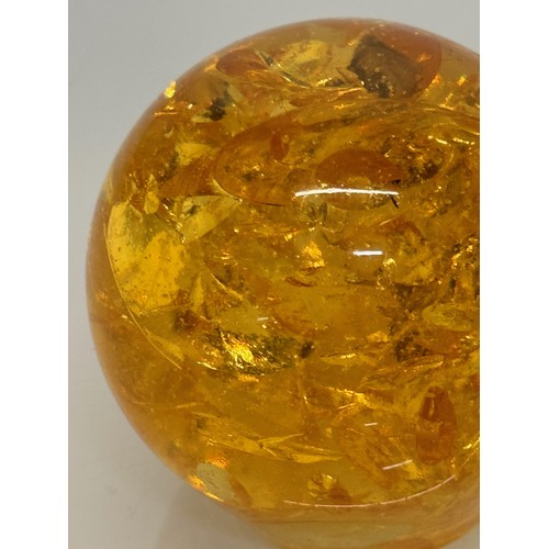 133 - An amber coloured resin paperweight, 6 cm high.

This lot is available for in-house shipping