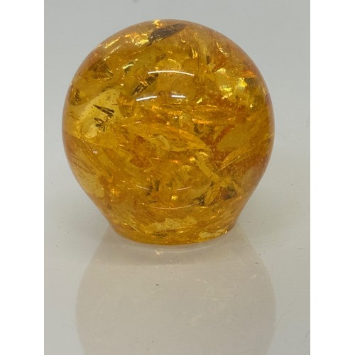 133 - An amber coloured resin paperweight, 6 cm high.

This lot is available for in-house shipping