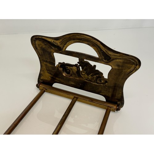 371 - Automobilia, a folding books stand the ends feature an Edwardian racing car at speed.

This lot is a... 